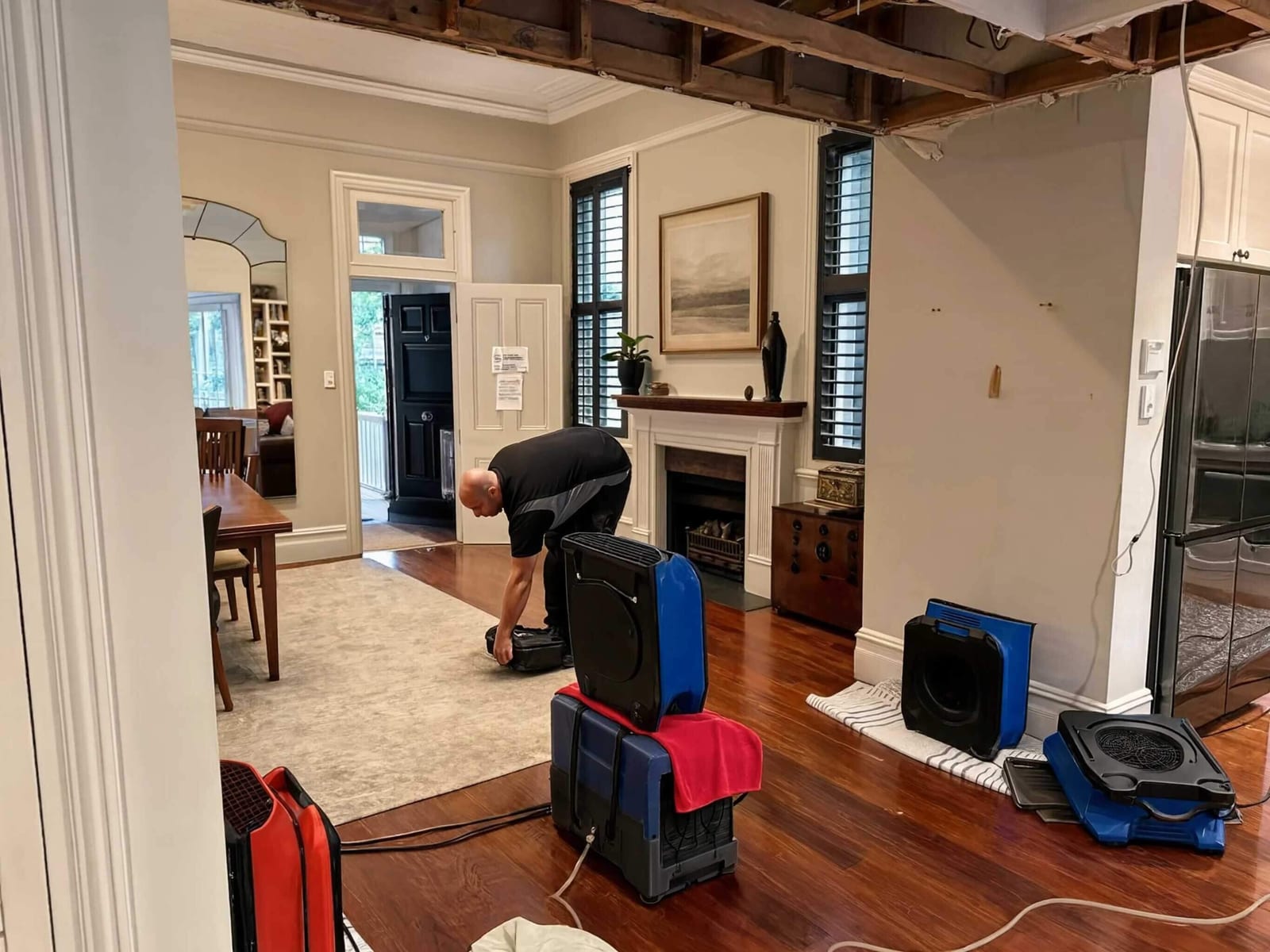 Air movers and dehumidifiers running in a Dallas home's living room after an emergency water loss