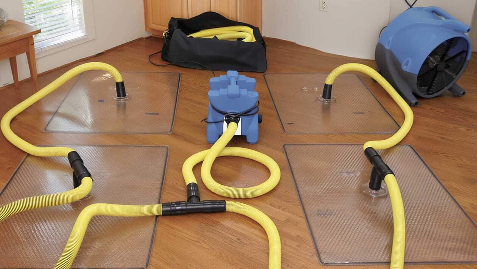 Specialized floor-mat drying system pulling moisture from a hardwood floor in a Dallas, TX home